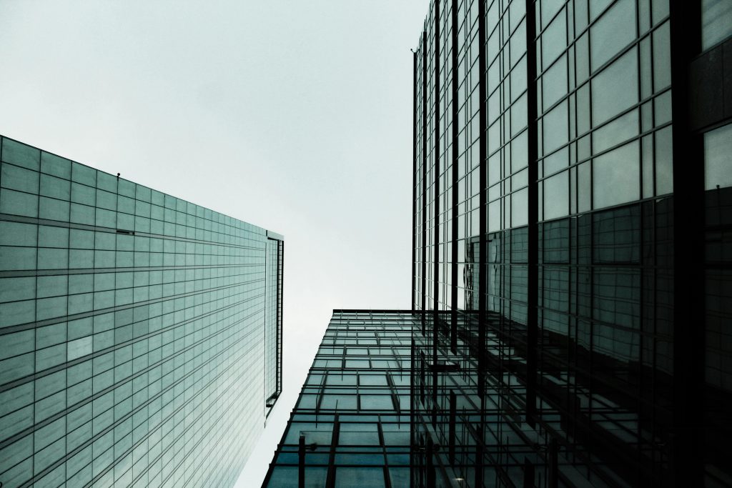 Low angle view of modern skyscrapers with glass facades in a cityscape.